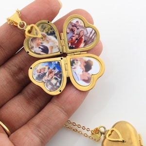 May include: Gold-tone necklace with a four-leaf clover locket that opens to reveal four heart-shaped compartments for photos. Each compartment has a different photo of a family.