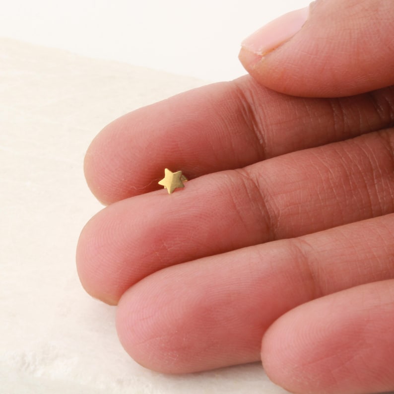 May include: A small gold star-shaped stud earring.