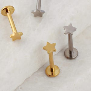 May include: Three gold and silver star-shaped body jewelry pieces. The jewelry is made of surgical steel and is available in a variety of colors.