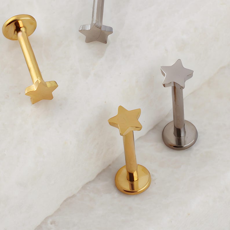 May include: Three gold and silver star-shaped body jewelry pieces. The jewelry is made of surgical steel and is available in a variety of colors.