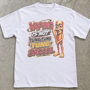 May include: A white short-sleeved t-shirt featuring a graphic print with the text VAPING IS NOT TUNG TUNG TUNG SACOOL. The design includes a cartoonish, light brown, cylindrical character with large eyes holding a wooden baseball bat.