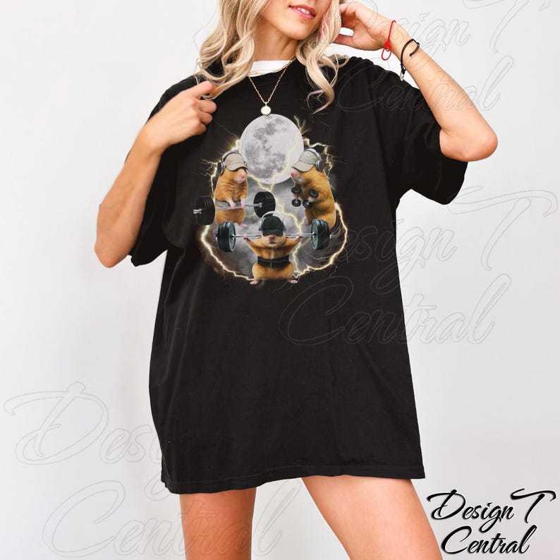May include: Black t-shirt featuring a graphic of three hamsters weightlifting with a full moon in the background. The hamsters are wearing hats and lifting barbells. The shirt has a white collar.
