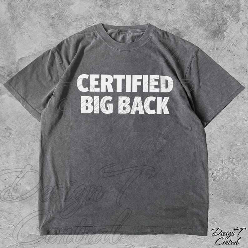 May include: Grey t-shirt featuring the white text "CERTIFIED BIG BACK". The shirt has a crew neck and short sleeves. The fabric appears to be a soft, washed material. A casual, everyday garment.
