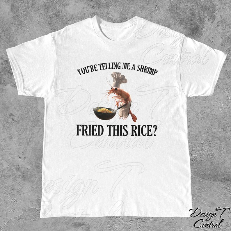 May include: White t-shirt with a funny graphic of a shrimp wearing a chef's hat and holding a pan of fried rice. The text on the shirt reads "You're telling me a shrimp fried this rice?"