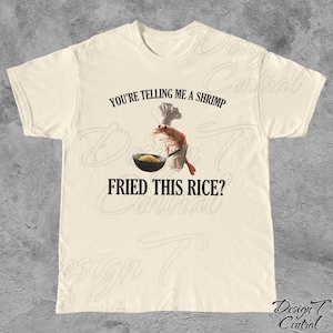 May include: A white t-shirt with the text "You're telling me a shrimp fried this rice?" and a cartoon shrimp wearing a chef's hat and holding a pan of rice.