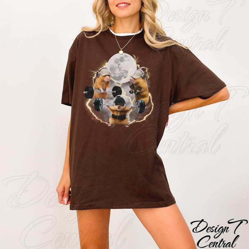 May include: A brown t-shirt featuring a graphic of hamsters weightlifting under a full moon. The hamsters are wearing hats and headphones. The text "Design Central" is in the lower right corner.