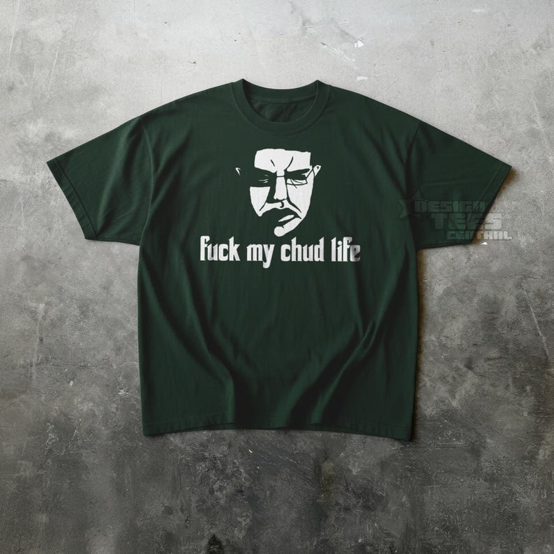 May include: Dark green t-shirt with a white graphic of a face and the text "fuck my chud life". The shirt is made of a soft material and has short sleeves.