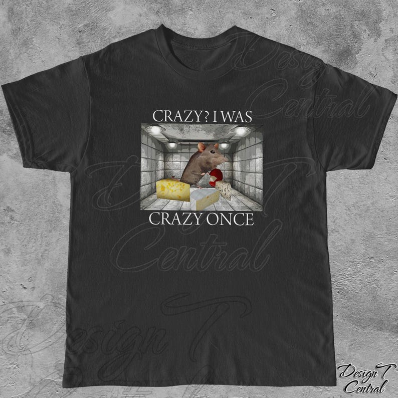 Puede incluir: Camiseta negra con un gr&aacute;fico de una rata en una habitaci&oacute;n con queso, con el texto "Crazy? I was crazy once". El dise&ntilde;o incluye una rata sosteniendo un objeto rojo y varios tipos de queso.