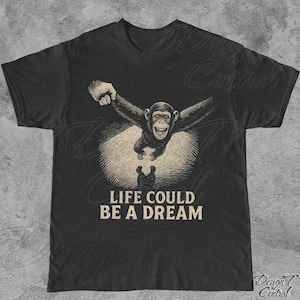 May include: Black t-shirt featuring a graphic of a monkey flying through the air with the text "Life could be a dream".