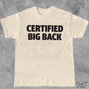 May include: A cream-coloured t-shirt featuring the text "CERTIFIED BIG BACK" in bold, black lettering. The shirt has a crew neck and short sleeves. The design is centrally placed on the front of the garment.