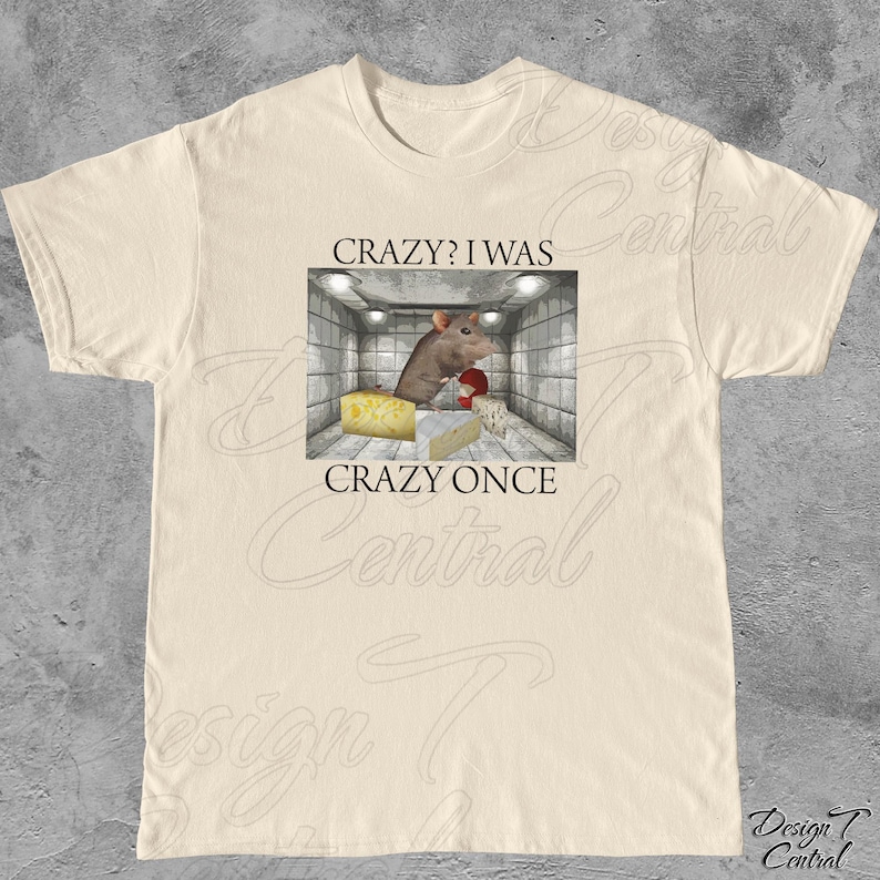 Puede incluir: Camiseta color crema con un gr&aacute;fico de una rata en una habitaci&oacute;n con queso y el texto "CRAZY? I WAS CRAZY ONCE". El gr&aacute;fico est&aacute; en un marco rectangular. La camiseta es de un material suave.