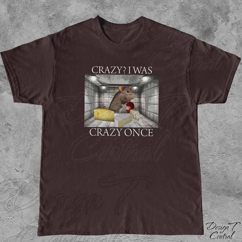 Puede incluir: Camiseta marr&oacute;n con un dise&ntilde;o humor&iacute;stico. El dise&ntilde;o muestra una rata de dibujos animados en una habitaci&oacute;n con queso y guantes de boxeo, con el texto "CRAZY? I WAS CRAZY ONCE".