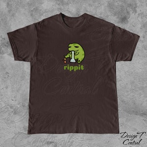 May include: A brown t-shirt with a green frog cartoon wearing a hat and smoking a bong. The text "rippit" is printed below the frog.