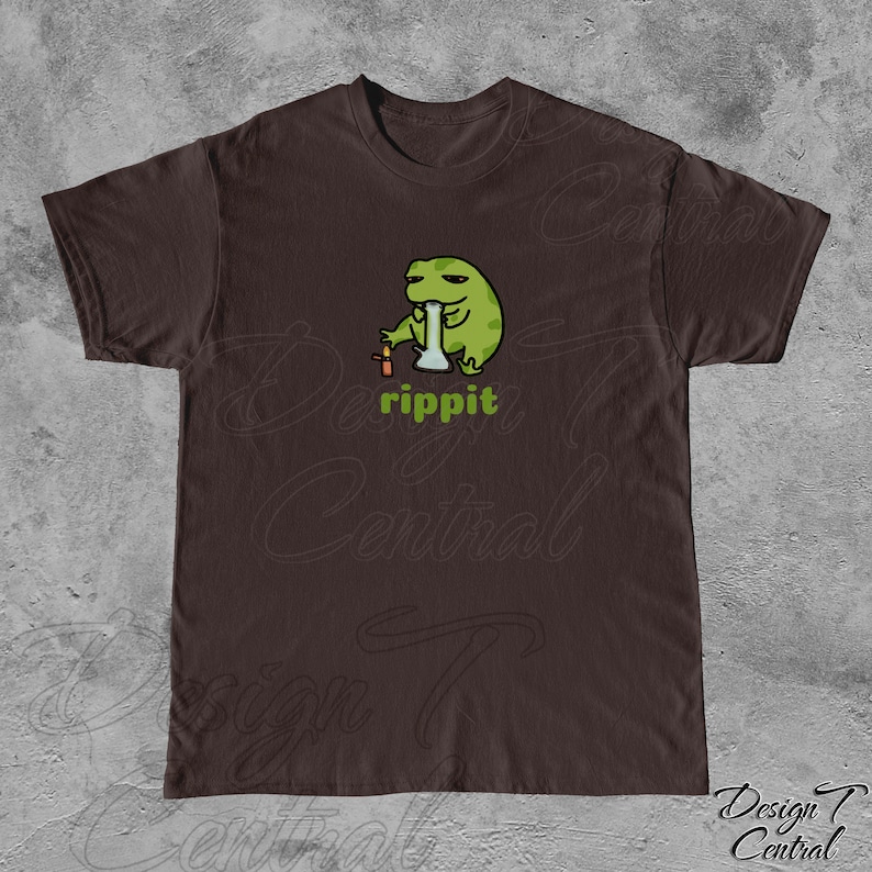 May include: A brown t-shirt with a green frog cartoon wearing a hat and smoking a bong. The text "rippit" is printed below the frog.