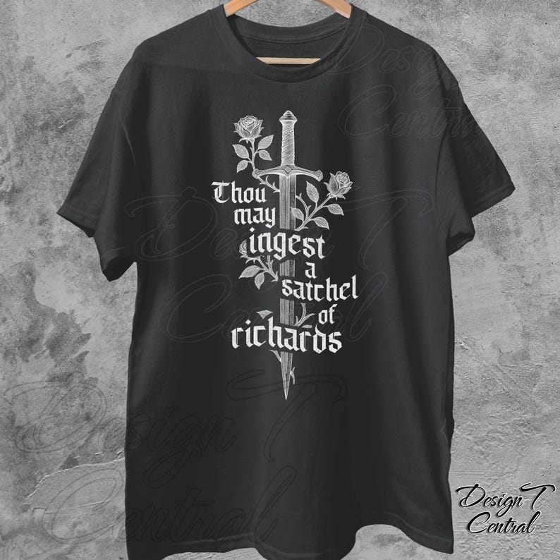 以下が含まれることがあります： 黒いTシャツ。白いグラフィックは剣、バラ、そして「Thou may ingest a satchel of richards」というテキストが特徴です。シャツは木製のハンガーに展示されています。
