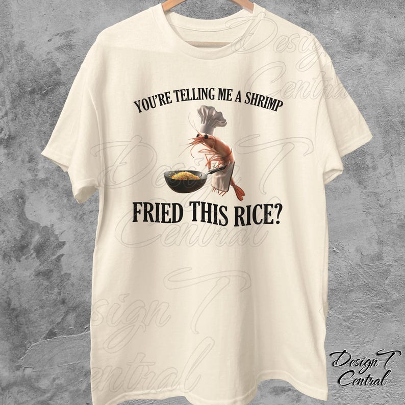 May include: A white t-shirt with a graphic of a shrimp wearing a chef's hat and holding a pan of fried rice. The text "You're telling me a shrimp fried this rice?" is printed on the shirt.