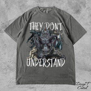 May include: Gray t-shirt with a graphic print of a wolf and other creatures. The text "They Don't Understand" is printed in white below the graphic.