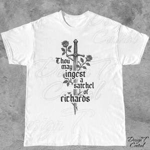以下が含まれることがあります： 白いTシャツ。黒い剣、バラ、そして「Thou may ingest a satchel of richards」というテキストのグラフィックが特徴です。デザインはシャツの中央に配置されています。