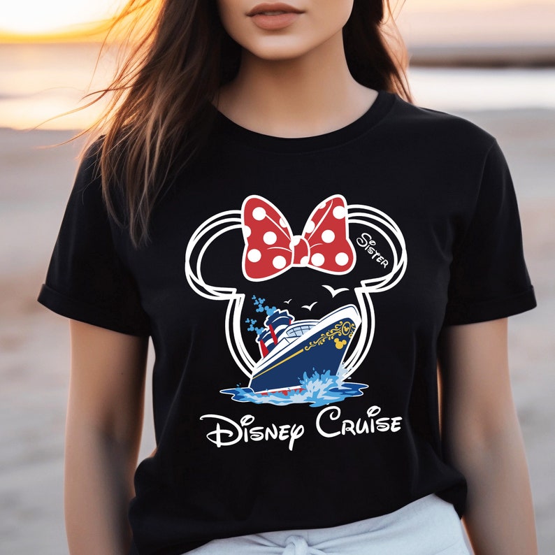 May include: Black t-shirt with a white outline of Mickey Mouse ears with a red and white polka dot bow. The text "Sister" is written on the right ear. Inside the ears is a blue and gold Disney cruise ship with white seagulls flying above. The text "Disney Cruise" is written below the ship.
