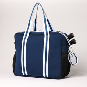 May include: A navy blue duffel bag with white stripes and a black mesh pocket. The bag has a top handle and a shoulder strap.