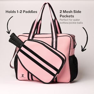 May include: Pink and black paddle bag with two side mesh pockets. The bag has a black and pink striped design and the text "ELEVBT" on the front. Holds 1-2 paddles.