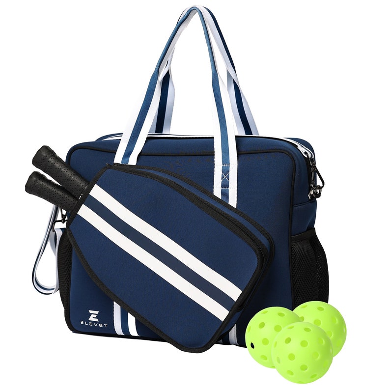 May include: A navy blue and white striped duffel bag with a separate pocket for paddles. The bag has a zipper closure and a mesh pocket on the side. Three bright green pickleball balls are in front of the bag.