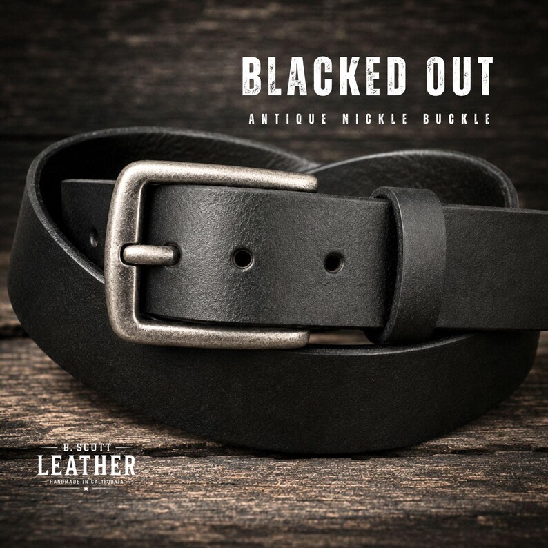 May include: A black leather belt featuring an antique nickel buckle. The text BLACKED OUT ANTIQUE NICKLE BUCKLE is visible at the top, and B. SCOTT LEATHER HANDMADE IN CALIFORNIA is printed at the bottom of the image.