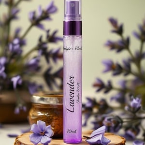 Puede incluir: Un frasco pulverizador cilíndrico que contiene un líquido de color morado claro. La etiqueta muestra el texto "Sylvie's Blend", "Lavender", "Shocker Wize" y "10ml". El frasco tiene una tapa transparente y un cuello morado oscuro.