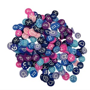 May include: A collection of small, round, colorful zodiac sign embellishments. The embellishments are in shades of pink, blue, purple, and white. Each one features a different zodiac symbol.