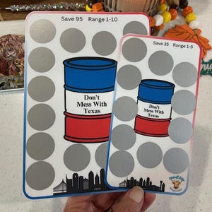 Puede incluir: Dos tarjetas blancas con fondo plateado y un gráfico de barril de petróleo rojo, blanco y azul. El texto en las tarjetas dice "Don't Mess With Texas". Las tarjetas tienen un rango de números y una cantidad de ahorro. La tarjeta de la izquierda dice "Save 95 Range 1-10" y la tarjeta de la derecha dice "Save 35 Range 1-5".