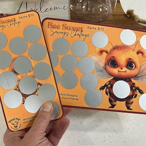Könnte beinhalten: Zwei orangefarbene und rote Karten mit einem Bienen-Motiv. Die Karten haben ein Raster aus silbernen Kreisen mit dem Text "Bee Sweet Savings Challenge" und dem zu sparenden Betrag, 70 € und 75 €. Eine Karte zeigt eine Cartoon-Biene mit Flügeln.
