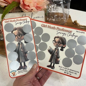 May include: Two Girl Math Professor Savings Challenge cards with a cartoon girl wearing glasses and a book. The cards have a red background with silver circles that can be scratched off. The text on the cards reads "Girl Math Professor Savings Challenge" and "Save $75". The text on the bottom of the card reads "Roll a die & determine your Girl Math IQ $3-$7 ea".