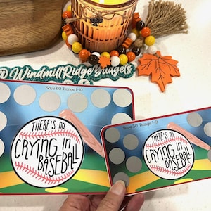 Pode incluir: Dois quadros de apagamento a seco com tema de beisebol com um gráfico de beisebol e taco e o texto "There's no crying in baseball". Os quadros têm 10 e 9 círculos para escrever, e o texto "Save 60 Range 1-10" e "Save 50 Range 1-9" está impresso na parte superior de cada quadro.
