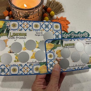 Puede incluir: Dos tarjetas azules y blancas con patrones y círculos plateados. La tarjeta superior dice "Make Lemonade with Friends" y "Save 45 Range 3-9". La tarjeta inferior dice "Make Lemonade with Friends" y "Save 40 Range 5-9".