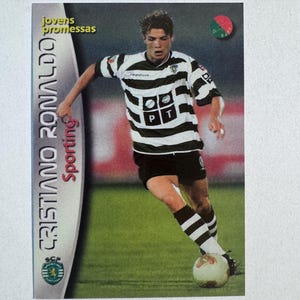 Puede incluir: Tarjeta coleccionable de Cristiano Ronaldo con la camiseta del Sporting de Lisboa. La tarjeta tiene un diseño verde, negro y blanco. El texto "CRISTIANO RONALDO Sporting" está impreso a la izquierda. El texto "jovens promessas" está arriba.