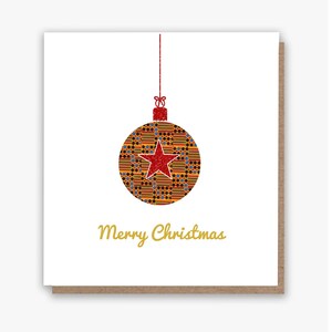 May include: A square Christmas card with a brown border. The card features a hanging ornament with a red star and a patterned design in shades of orange, yellow, blue, and black. The words "Merry Christmas" are written in gold.