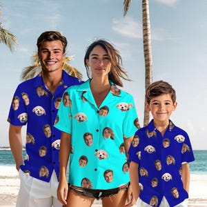 Könnte beinhalten: Drei kurzärmelige Button-Down-Hemden. Eines ist blau und zwei sind türkis. Jedes Hemd hat ein sich wiederholendes Muster aus Gesichtern und Welpen. Die Hemden werden von drei Personen am Strand getragen.