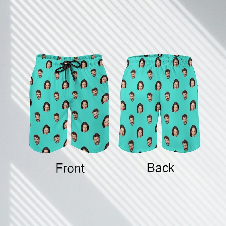 May include: A pair of turquoise swim trunks with a repeated pattern of a man's face. The front and back of the trunks are shown.