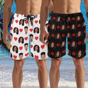 Puede incluir: Dos pares de pantalones de baño negros y blancos con un patrón de caras y corazones rojos. Los pantalones de baño tienen una cintura con cordón.