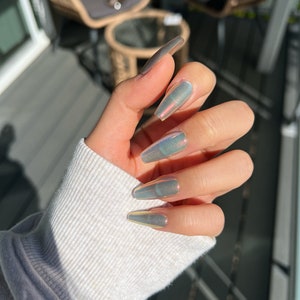 May include: Long, iridescent, light gray coffin-shaped press-on nails.