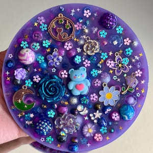 Celestial Amethyst Picky Pad for Skin Picking & Stress Relief Close-Up of Bead-Filled Sensory Fidget Pad with Moon & Star Charms Silicone Picking Pad with Purple Galaxy Theme & Glitter Details Anxiety & Nail Biting Relief Picky Pad with Beads & Cosmic Accents Fidget Pick Pad for ADHD, OCD & Astrology Lovers