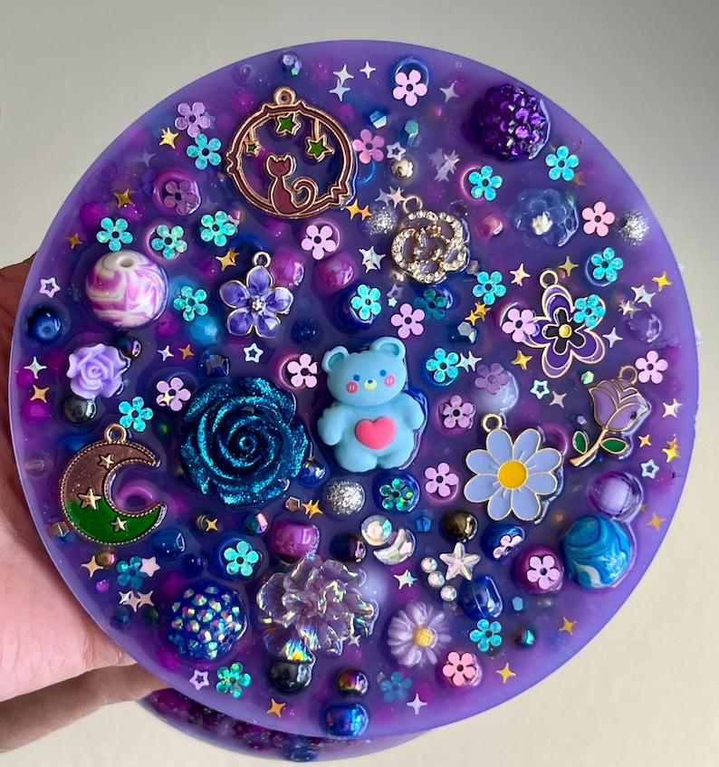 Celestial Amethyst Picky Pad for Skin Picking & Stress Relief Close-Up of Bead-Filled Sensory Fidget Pad with Moon & Star Charms Silicone Picking Pad with Purple Galaxy Theme & Glitter Details Anxiety & Nail Biting Relief Picky Pad with Beads & Cosmic Accents Fidget Pick Pad for ADHD, OCD & Astrology Lovers