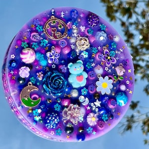 Celestial Amethyst Picky Pad for Skin Picking & Stress Relief Close-Up of Bead-Filled Sensory Fidget Pad with Moon & Star Charms Silicone Picking Pad with Purple Galaxy Theme & Glitter Details Anxiety & Nail Biting Relief Picky Pad with Beads & Cosmic Accents Fidget Pick Pad for ADHD, OCD & Astrology Lovers