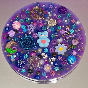 Celestial Amethyst Picky Pad for Skin Picking & Stress Relief Close-Up of Bead-Filled Sensory Fidget Pad with Moon & Star Charms Silicone Picking Pad with Purple Galaxy Theme & Glitter Details Anxiety & Nail Biting Relief Picky Pad with Beads & Cosmic Accents Fidget Pick Pad for ADHD, OCD & Astrology Lovers