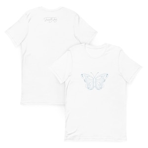 May include: White t-shirt with a blue butterfly design on the front and the text "Just Joy" on the back.