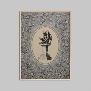 May include: A framed print featuring a detailed illustration of a gargoyle reading a book atop a pedestal, set within an oval frame. The background is a textured gray with floral patterns, all encased in a wooden frame.