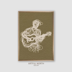May include: A digital art print of a line drawing of a person playing a guitar. The print is on a brown background and is framed in a gold frame. The text "ARTFUL NORTH DECOR" is below the frame.
