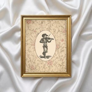 May include: A framed print featuring a skeleton playing a violin. The skeleton is in an oval frame against a floral patterned background. The frame is gold-colored.