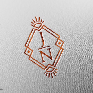 May include: A gold geometric monogram featuring the letters "J" and "N" within a square frame, adorned with sunburst designs at the top and bottom.