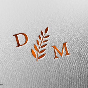Könnte beinhalten: Ein Monogramm mit den Buchstaben "D" und "M" in Kupferfarbe. Ein stilisierter Zweig mit Blättern befindet sich zwischen den Buchstaben.